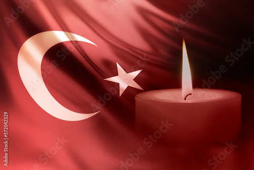 Turkey, earthquake in Turkey. catastrophe, mourning, disaster. Turkey Earthquake, February 6, 2023. Mournful banner. A bright burning candle on the background of the Turkish flag. photo