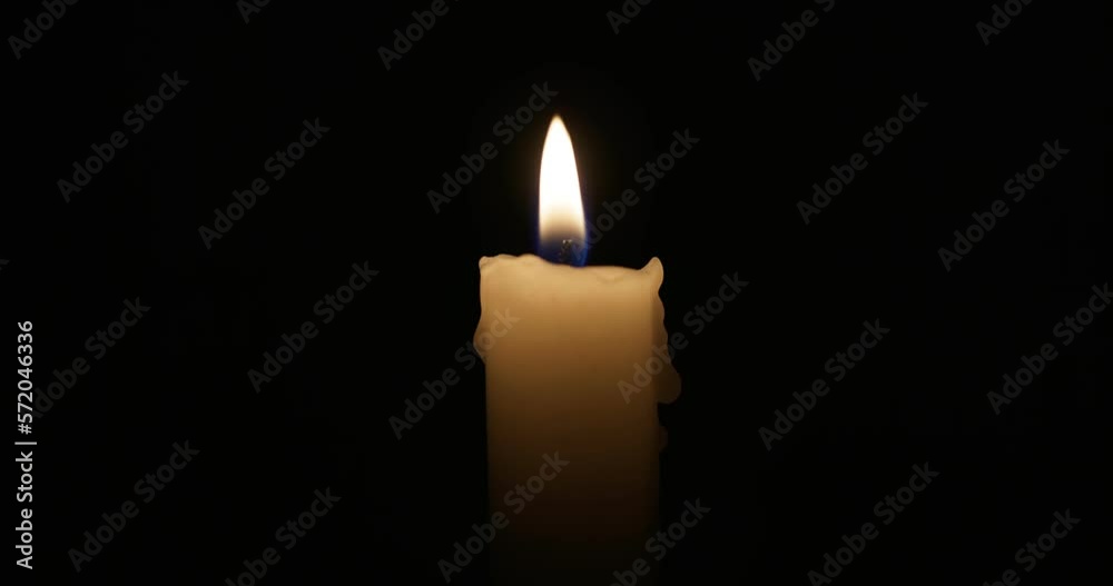 The candle burns with a soft yellow flame. Isolated candle burning The candle burns with a soft yellow flame. Isolated candle burning