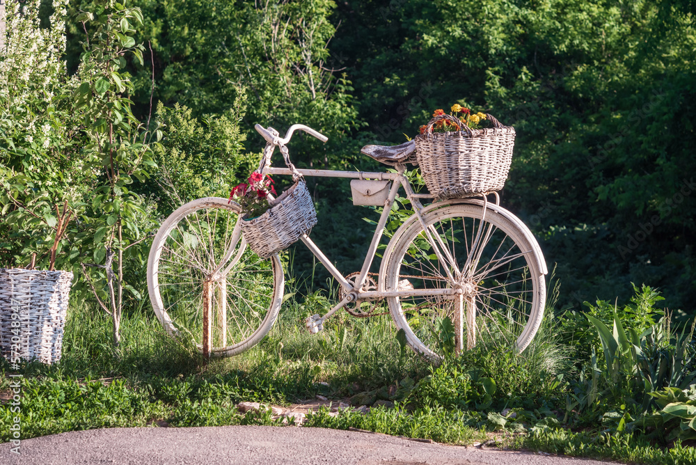 Decorative white old bike flowerbed in the street.