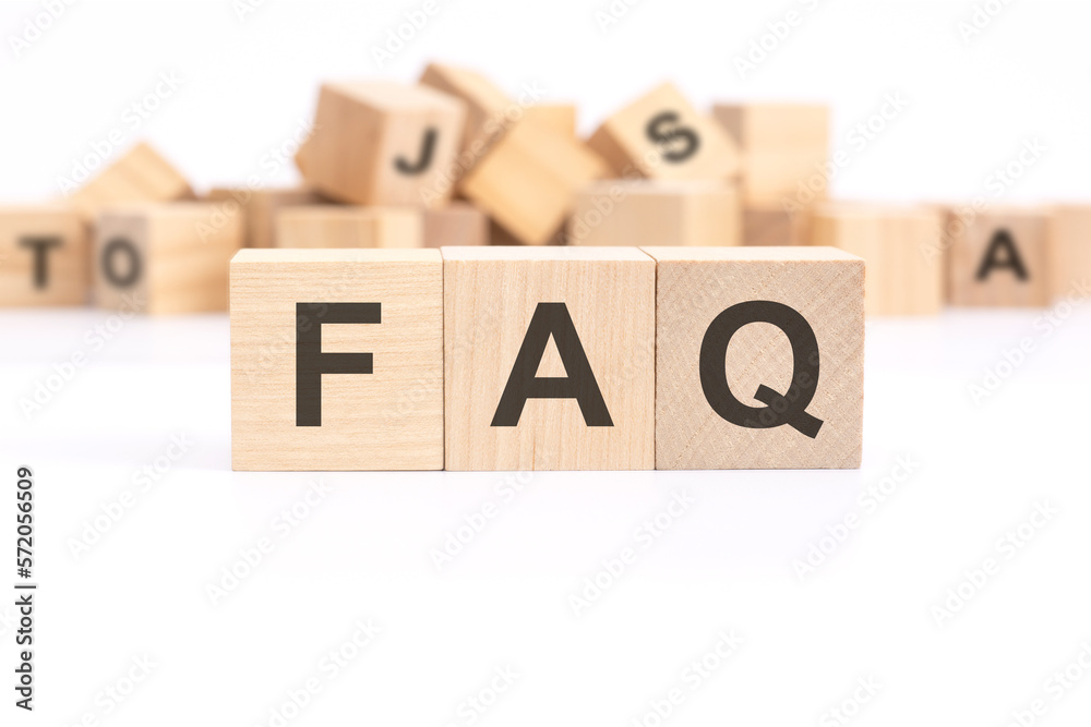 text FAQ - Frequency Asked Questions - is written on three wooden cubes standing on a white table. in the background - a mountain of wooden cubes with letters. text FAQ - Frequency Asked Questions - is written on three wooden cubes standing on a white table. in the background - a mountain of wooden cubes with letters.