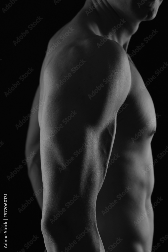 Attractive Muscular male Body. Chest , Shoulder muscles , Biceps close up. Black and White Low Key Photography Attractive Muscular male Body. Chest , Shoulder muscles , Biceps close up. Black and White Low Key Photography