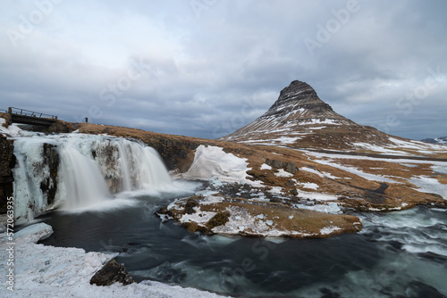 At the foot of the waterfall called Kirkjufellsfoss which is half iced over and doesn't have as much water flowing through it as in the summer.