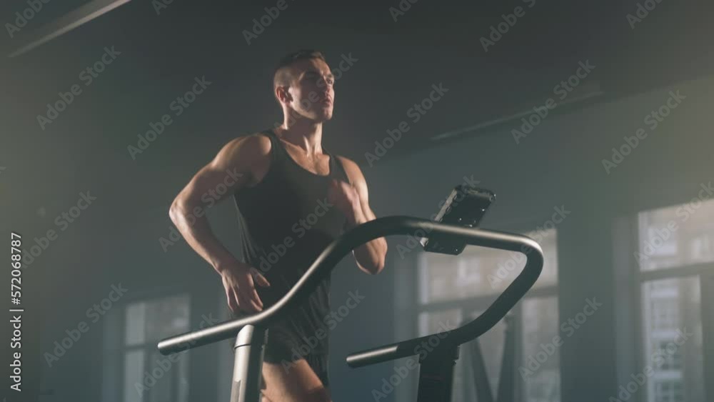 Close-up view of active, caucasian sportsman having intensive cardio workout to burn calories. Portrait of young, caucasian man jogging on gym machine. High quality 4k footage