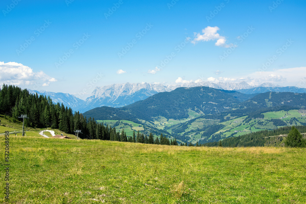 Panorama of Austrian Alps with forest and green meadow. Grafenberg Hill, Wagrain.