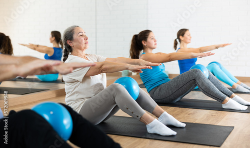 Canvastavla Sedulous old-aged woman doing pilates exercises with ball in gym area during workout session