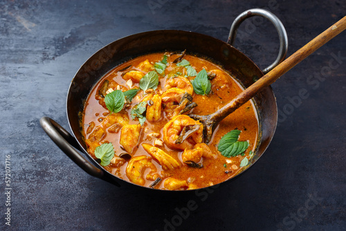 Traditional spicy Indian prawn Madras curry Rogan Josh with king prawns served as close-up in a korei bowl photo