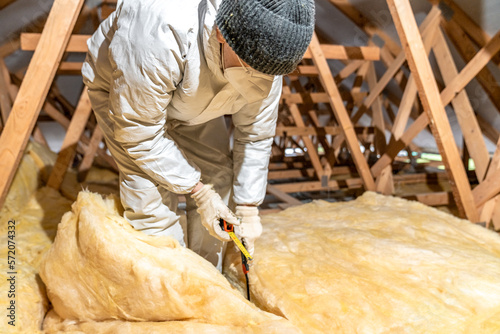 cutting glass wool when insulating the ceiling on the roof photo
