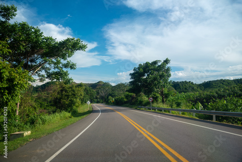 Highway in the Colombian countryside with a no overtaking traffic sign on the road.