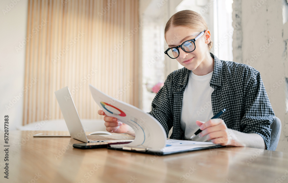 A woman in the office using a laptop computer in the workplace. Business report online work remotely. A woman in the office using a laptop computer in the workplace. Business report online work remotely.
