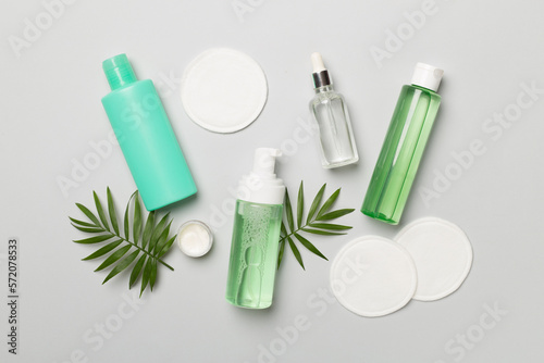 Face care products with eco pads on color background, top view