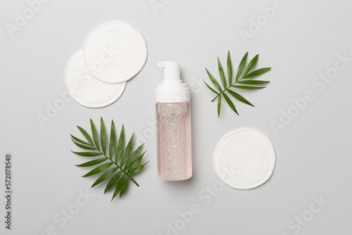 Foaming facial cleanser with eco pads on color background, top view photo
