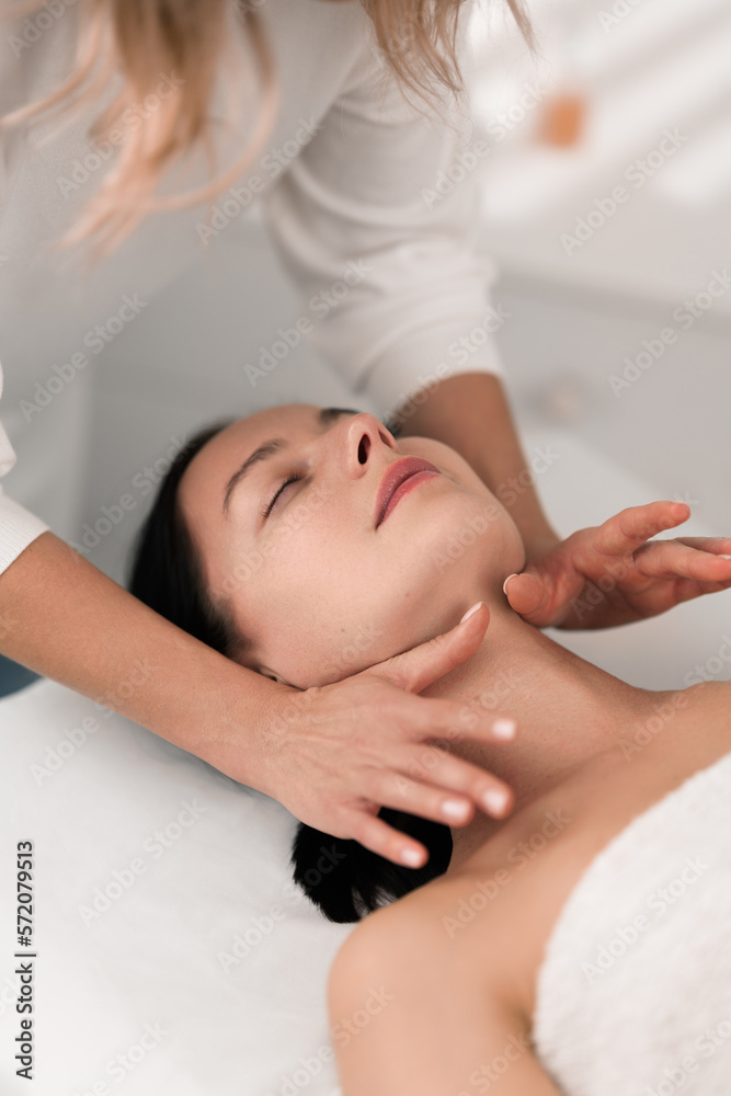 Crop masseuse massaging neck of female customer in salon Crop masseuse massaging neck of female customer in salon