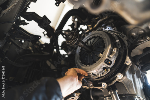 closeup shot of an auto mechanic installing a new clutch kit for a car, auto repair shop. High quality photo