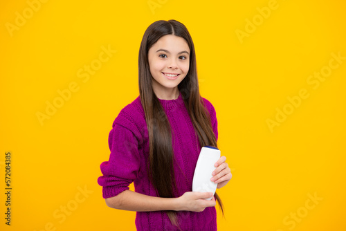 Teenage girl with shampoos conditioners or shower gel. Kids hair care cosmetic product, shampoo bottle.