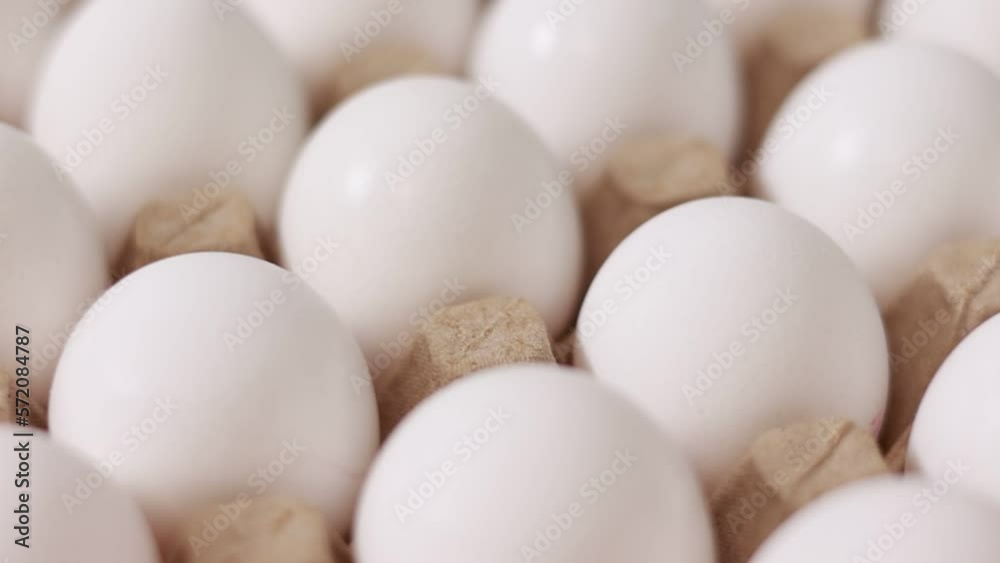 White chicken eggs in a cardboard box. Fresh raw eggs in a paper egg container for store and shop. egg tray with eggs on white table background. Top view. preparation to easter holiday. White chicken eggs in a cardboard box. Fresh raw eggs in a paper egg container for store and shop. egg tray with eggs on white table background. Top view. preparation to easter holiday.