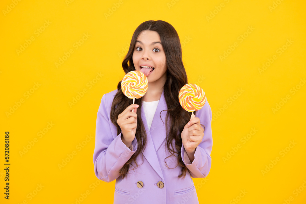 Cool teen child with lollipop over yellow isolated background. Sweet childhood life. Teen girl with yummy lollipop candy. Happy teenager, positive and smiling emotions of teen girl.