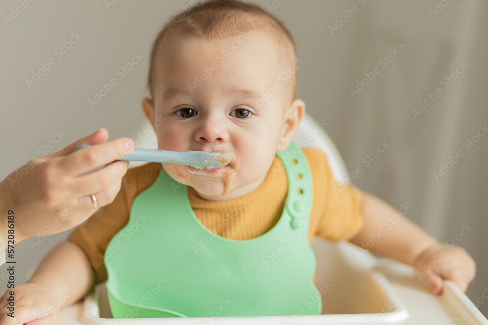 Baby being fed with a spoon of baby food Baby being fed with a spoon of baby food