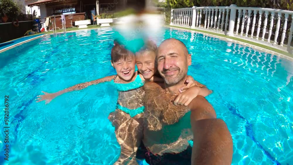 Happy family in the pool. Happy father dives into the pool with his