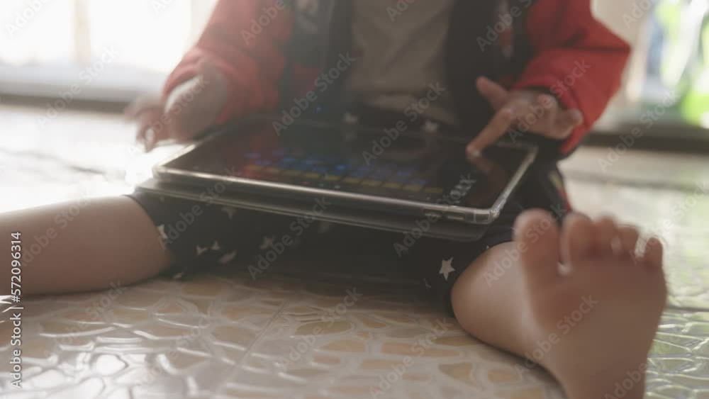 Asian boy is using a tablet alone in the living room. Asian boy is using a tablet alone in the living room.