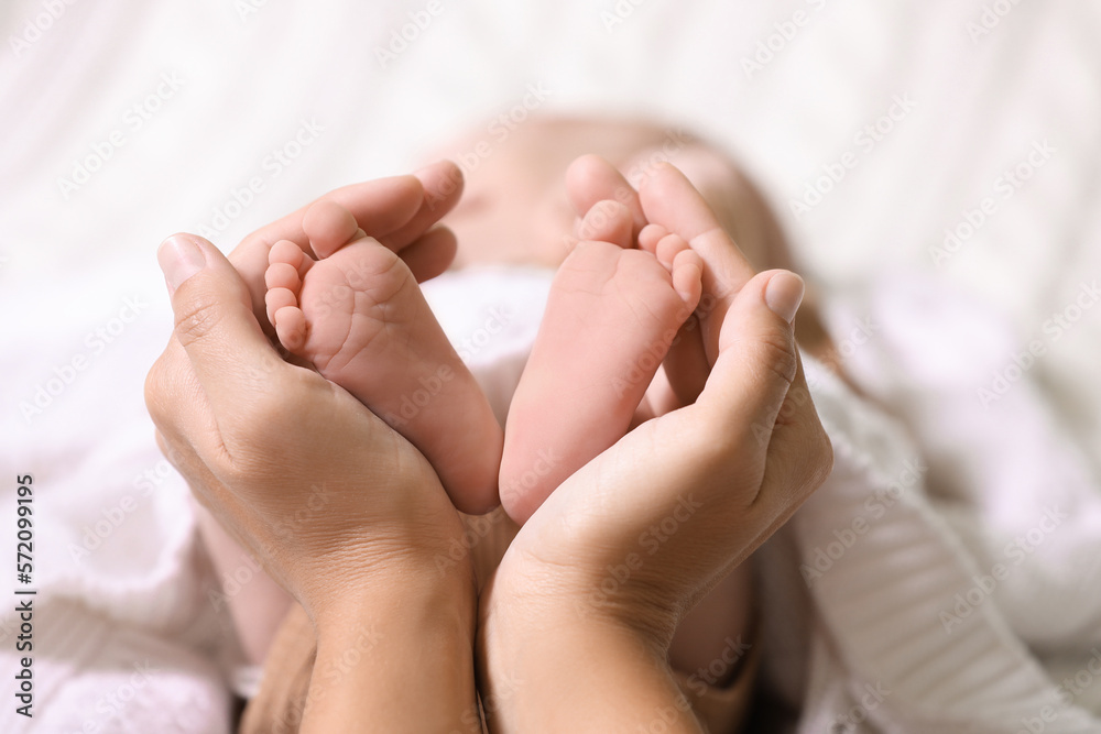 Mother and her newborn baby on bed, closeup. Space for text Mother and her newborn baby on bed, closeup. Space for text