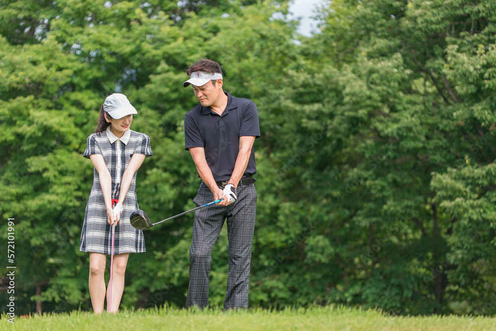 ゴルフ場でゴルフレッスンするゴルファーの男女（ティーショット・グリップの握り方ゴルフシューズ）　撮影協力：あづみ野カントリークラブ