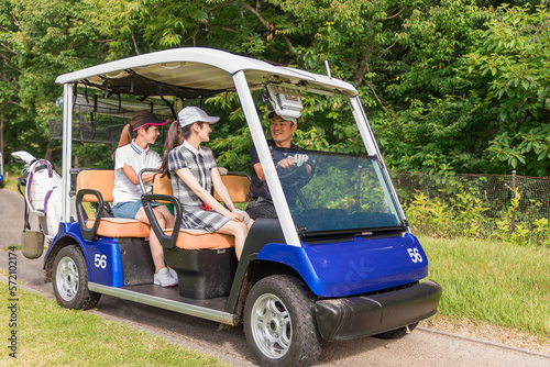 ゴルフ場でゴルフカートに乗るゴルファーの男女 撮影協力：あづみ野カントリークラブ