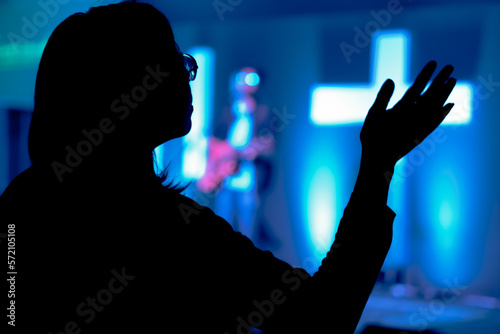 Silueta de persona clamando a Dios mientras canta