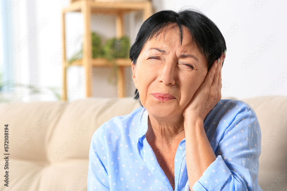 Senior woman suffering from ear pain at home. Space for text Senior woman suffering from ear pain at home. Space for text