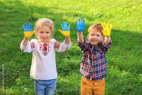 Little girl and boy with hands painted in Ukrainian flag colors outdoors. Love Ukraine concept