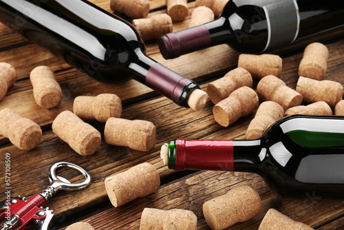 Obraz na płótnie Bottles with wine, corkscrew and corks on wooden table