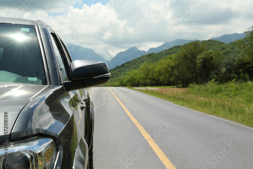 Car driving on asphalt road near mountains, closeup. Space for text © New Africa