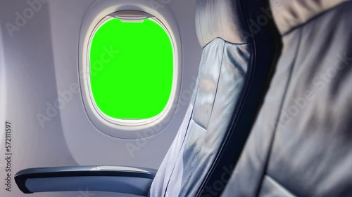 in the plane looking at the window of the plane with a green background