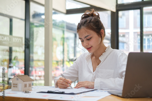 Portrait of businesswoman sitting at office desk and checking documents.