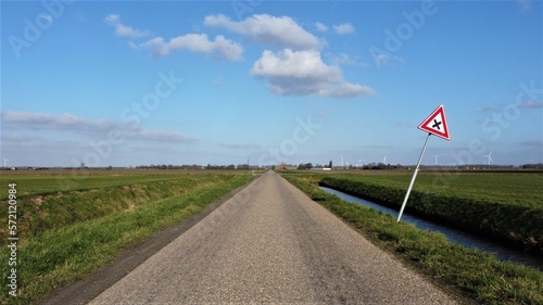 Crossroads in the countryside of the Netherlands. Between farmland, agricultural area. Make choices and take turns to change direction.