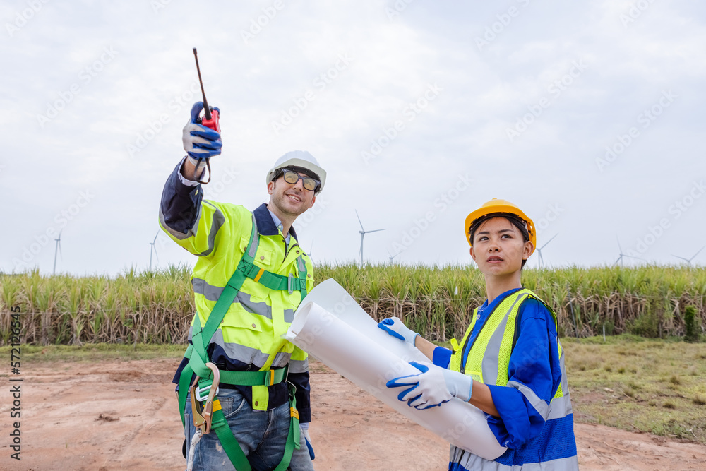 Team engineer of wind turbine worker pointing holding blueprint working about renewable energy at station energy power wind. technology protect environment reduce global warming problems. Team engineer of wind turbine worker pointing holding blueprint working about renewable energy at station energy power wind. technology protect environment reduce global warming problems.