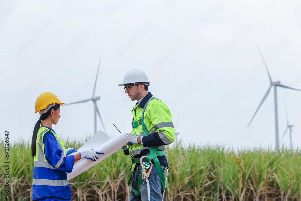 Team engineer of wind turbine worker pointing holding blueprint working about renewable energy at station energy power wind. technology protect environment reduce global warming problems. Team engineer of wind turbine worker pointing holding blueprint working about renewable energy at station energy power wind. technology protect environment reduce global warming problems.