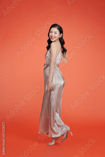 Young woman in a beautiful glamour dress on red background