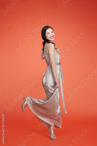 Ecstatic asian woman in sequins party dress dancing and having fun