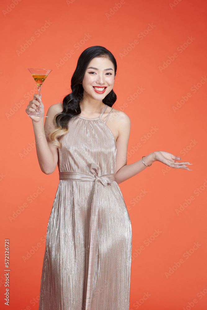 Beautiful young lady in glitter evening dress with wine glass in hand Beautiful young lady in glitter evening dress with wine glass in hand