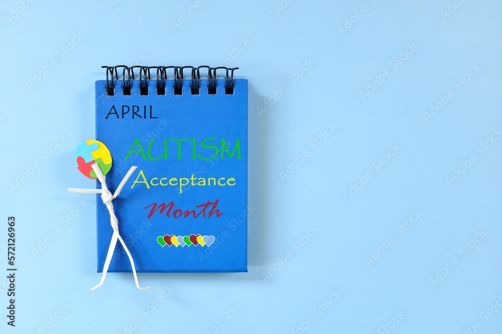 April as Autism Acceptance Month reminder on blue desk calendar. Celebration and support concept.
