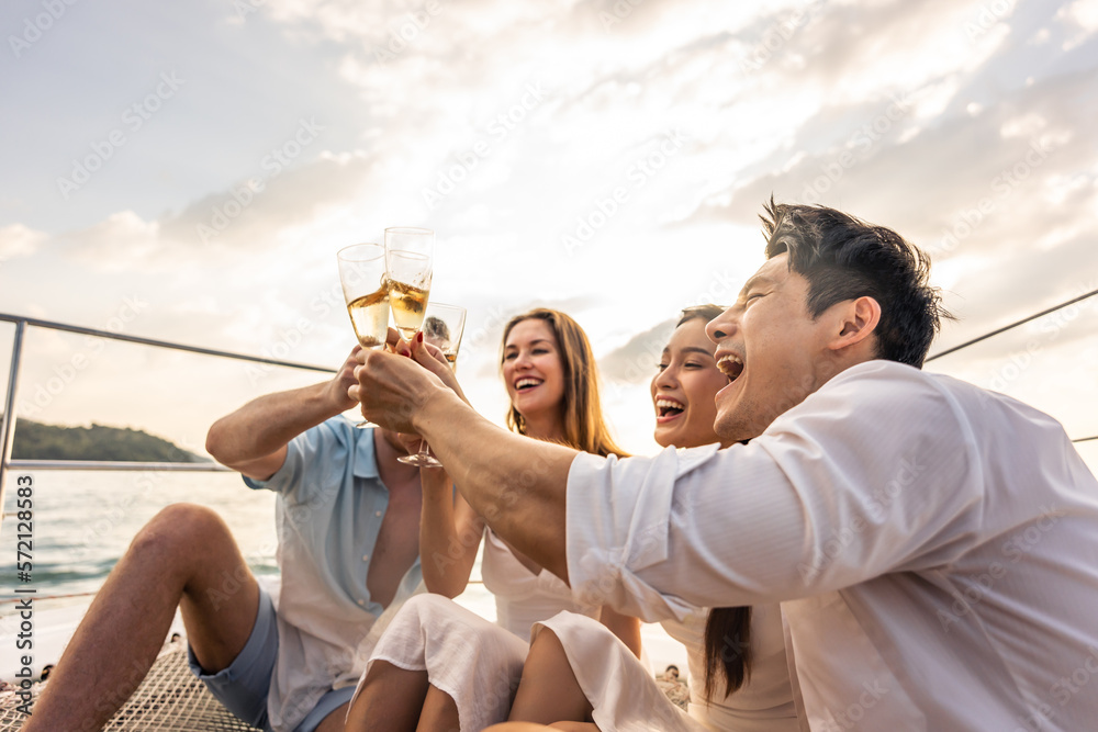 Group of diverse friends drink champagne while having a party in yacht - obrazy, fototapety, plakaty 