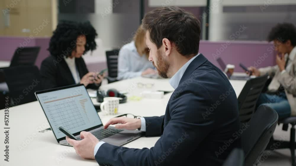 Close-up view of a man looking concerned and serious as he analyzing a report. Portrait of a handsome businessman working with his colleagues in modern office space. High quality 4k footage Close-up view of a man looking concerned and serious as he analyzing a report. Portrait of a handsome businessman working with his colleagues in modern office space. High quality 4k footage