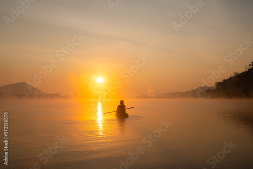 Women on kayak rows in the reservoir during the sunrise, Harirak forest park Huai Nam Man reservoir Loei Thailand 21 Jan 2023 © Thicha