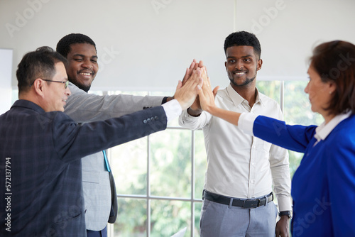 businesspeople giving high five pose and celebrating success at work in the office