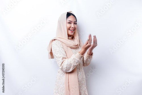 Religious beautiful Asian Muslim girl wearing a headscarf praying to God.