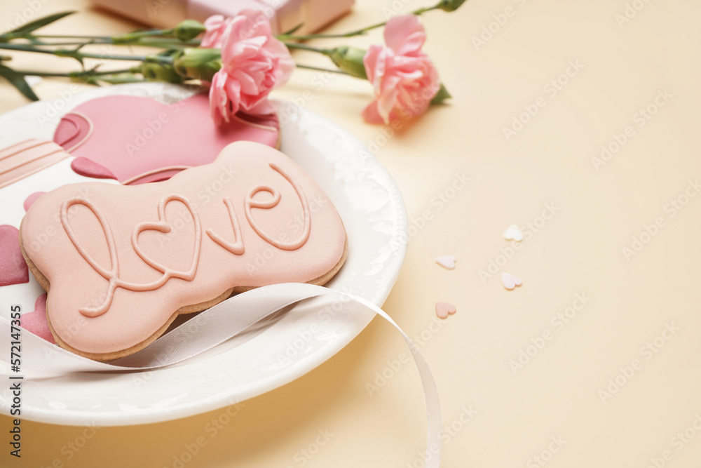 Plate with sweet cookies and carnation flowers on color background, closeup. Valentine's Day celebration
