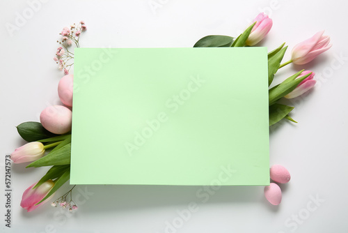 Fototapeta Naklejka Na Ścianę i Meble -  Composition with blank card, flowers and Easter eggs on white background