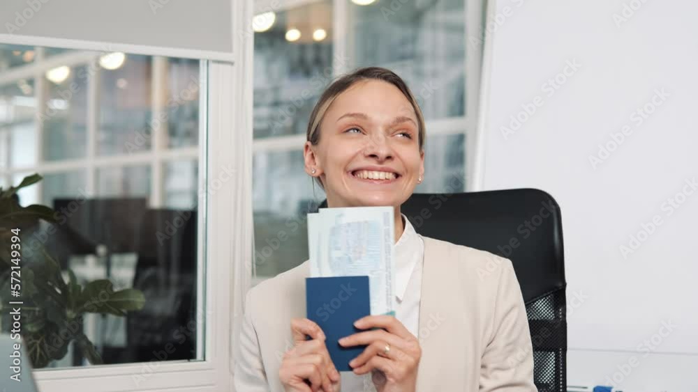 Surprised amazed woman, office worker holding passport with tickets. A cheerful girl is happy on vacation, dreams of a long-awaited family vacation. Female manager dancing with tickets at workplace. Surprised amazed woman, office worker holding passport with tickets. A cheerful girl is happy on vacation, dreams of a long-awaited family vacation. Female manager dancing with tickets at workplace.