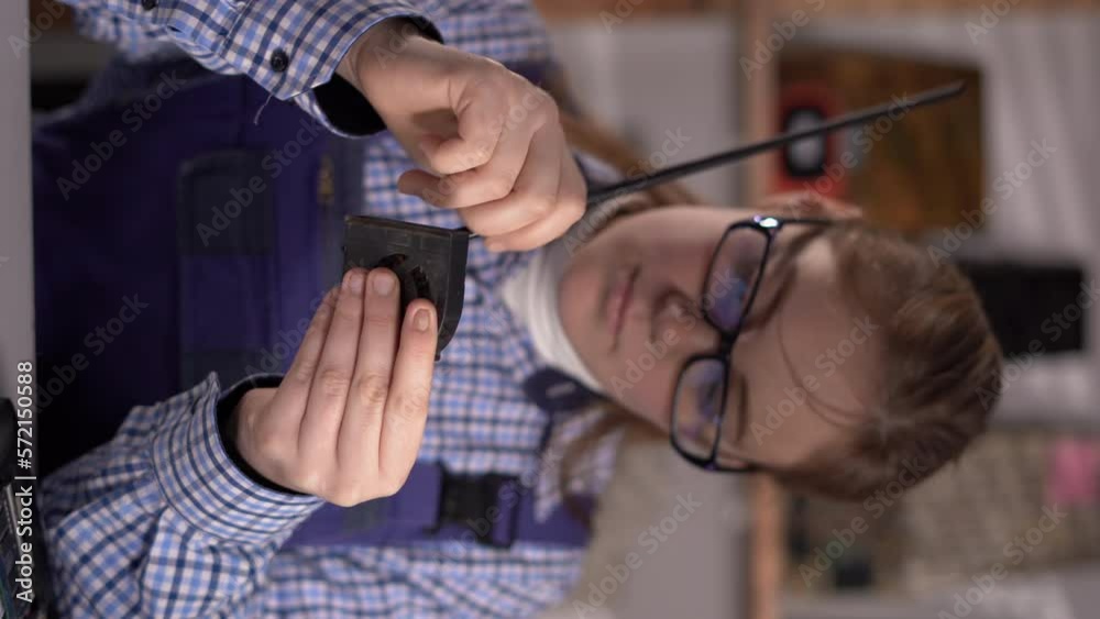 Woman technic cleaning the cooler system of laptop during maintenance or prophylaxis, removing the dust with little brush. Repairs of electronic device concept.
