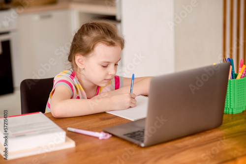 Distance learning online. A schoolgirl studies at home and does school homework. Distance learning at home.